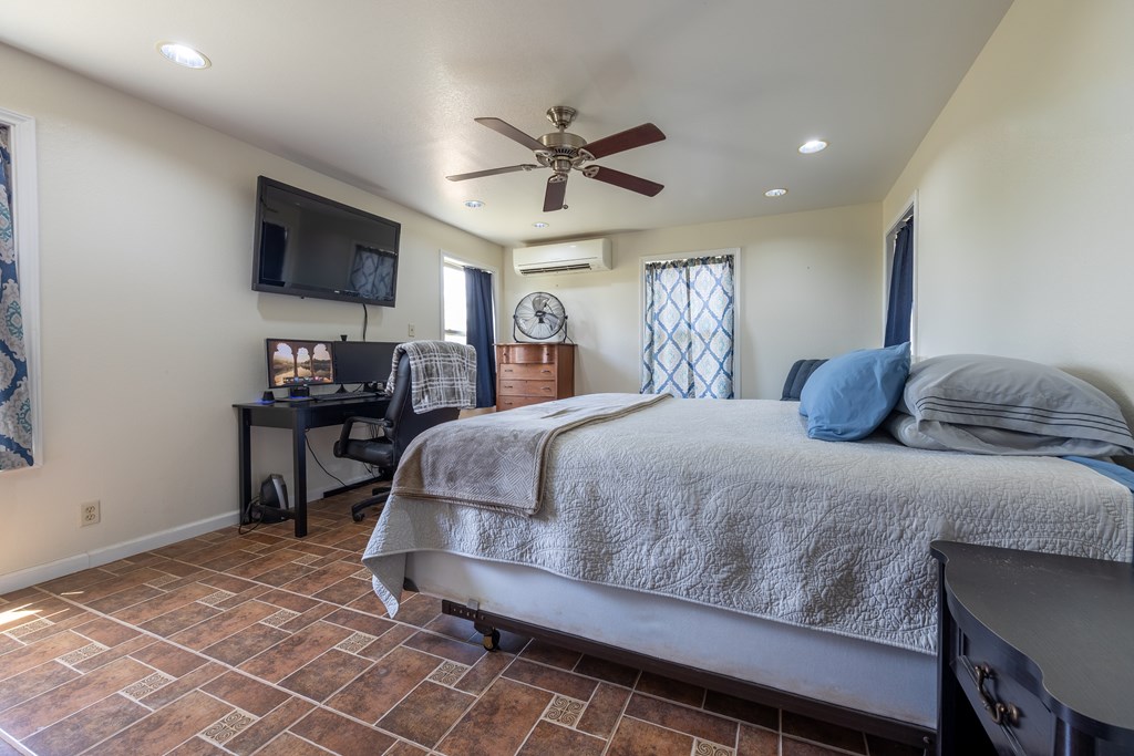 1596 Mule Creek Road Robert Lee, TX 76945 - Photo 9 of 98 a bedroom with a bed and a chandelier