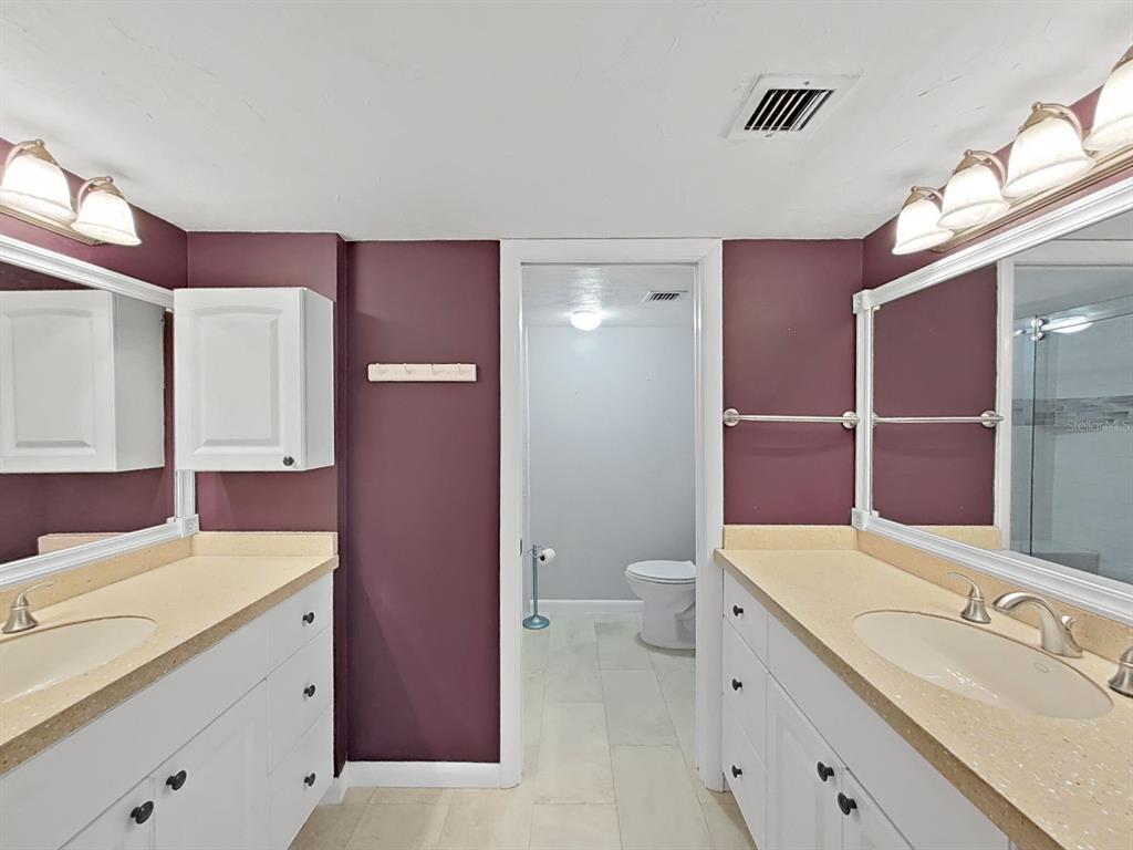 700 Starkey Road, Unit 511 Largo, FL 33771 - Photo 13 of 27 a bathroom with a sink a toilet a mirror and shower