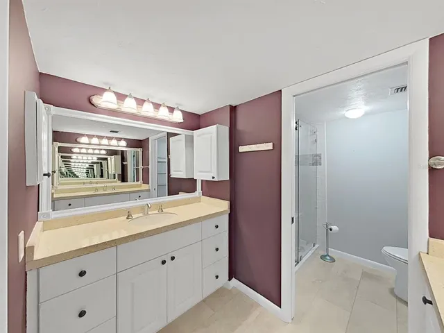 a spacious bathroom with a shower sink and mirror