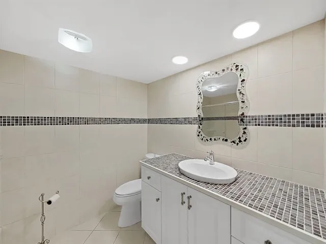 a bathroom with a granite countertop sink toilet and a mirror