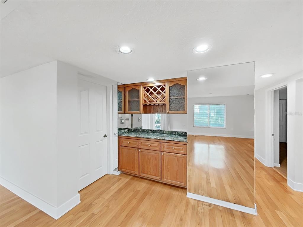 700 Starkey Road, Unit 511 Largo, FL 33771 - Photo 6 of 27 a kitchen with granite countertop white cabinets and wooden floor