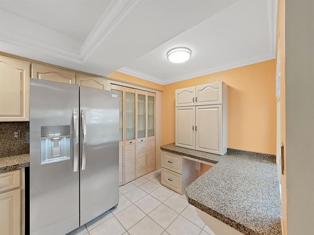 700 Starkey Road, Unit 511 Largo, FL 33771 - Photo 8 of 27 a kitchen with granite countertop a refrigerator and cabinets