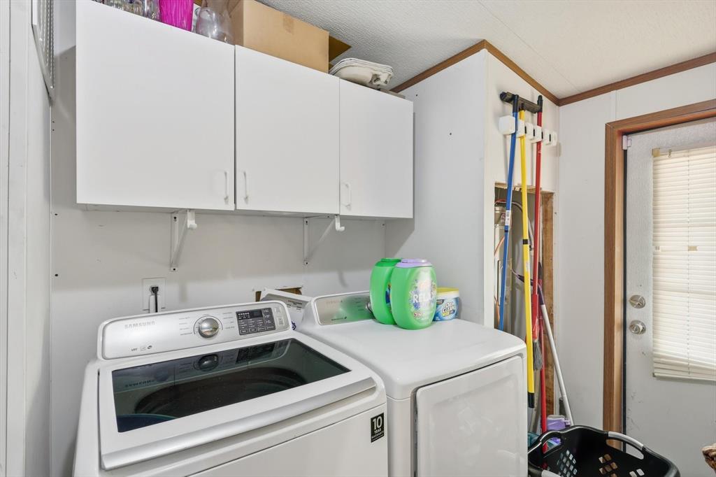 1200 Alliance Boulevard Rhome, TX 76078 - Photo 19 of 31 Laundry area with crown molding, cabinet space, and washing machine and clothes dryer