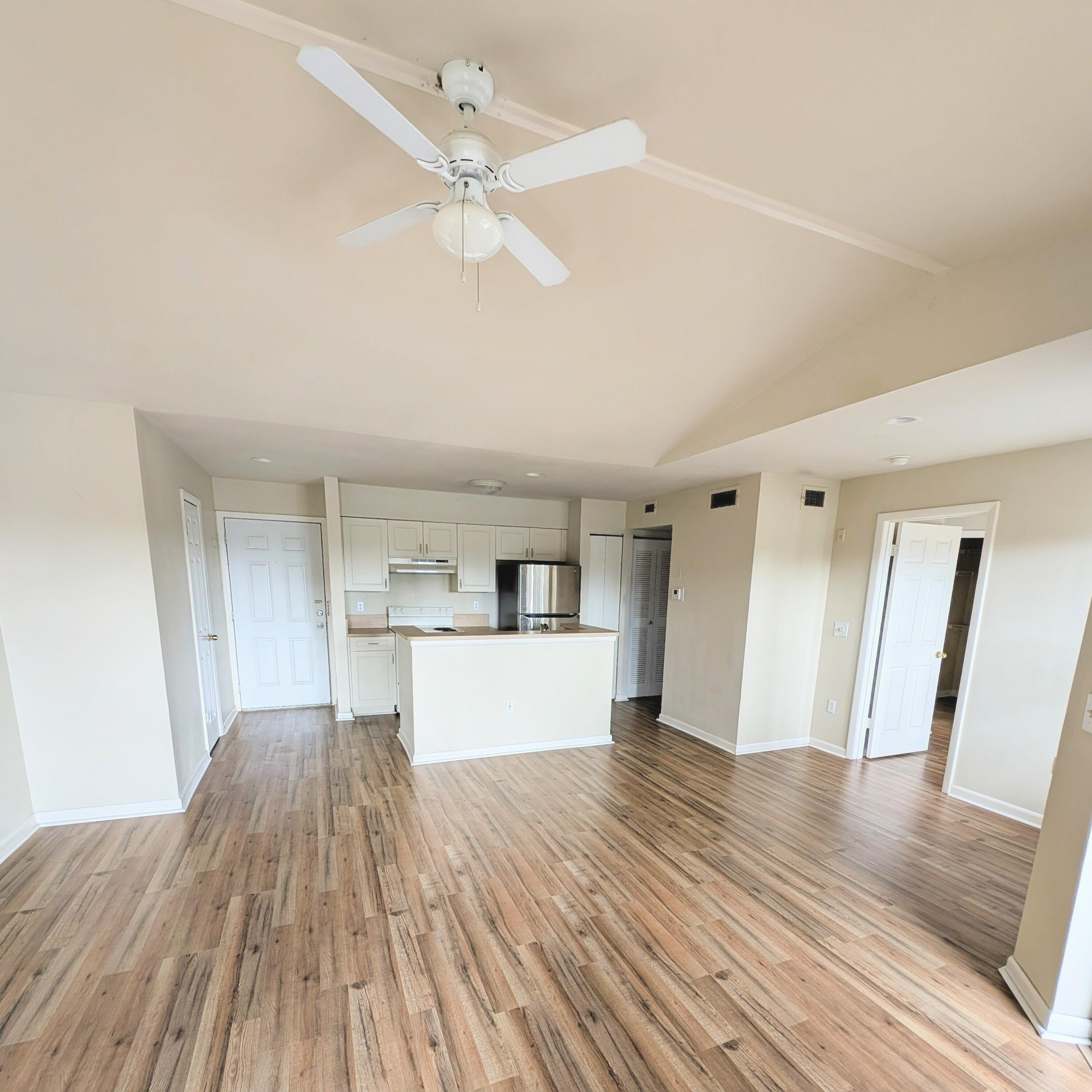a view of a kitchen with wooden floor and a ceiling fan