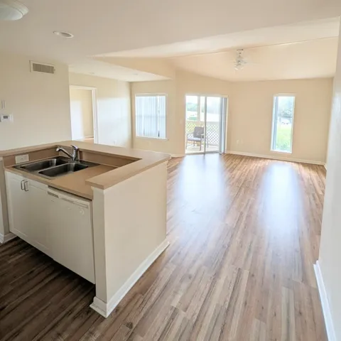 a kitchen that has a sink and wooden floor