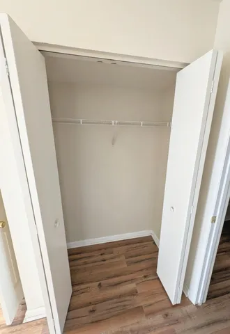 a view of walk in closet with wooden floor