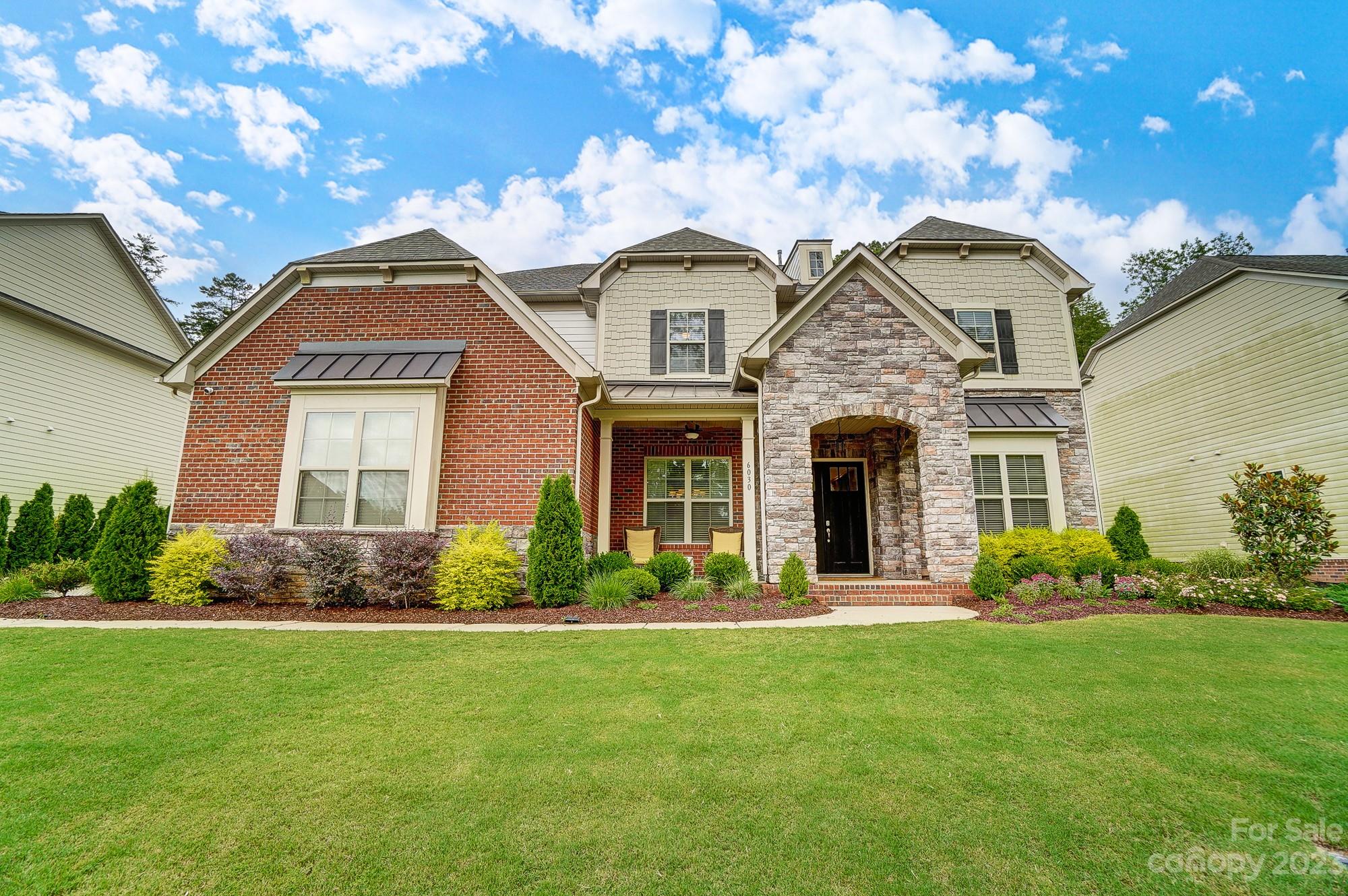 6030 Fallondale Road Waxhaw, NC 28173 - Photo 1 of 48 a front view of a house with a garden and plants