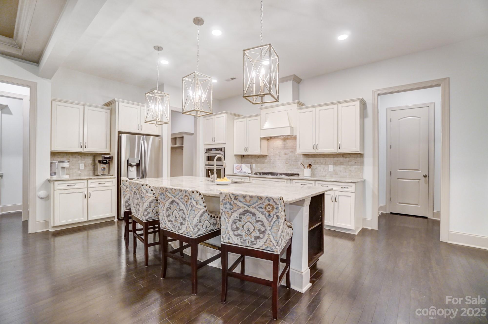 6030 Fallondale Road Waxhaw, NC 28173 - Photo 11 of 48 a large kitchen with cabinets wooden floor and stainless steel appliances