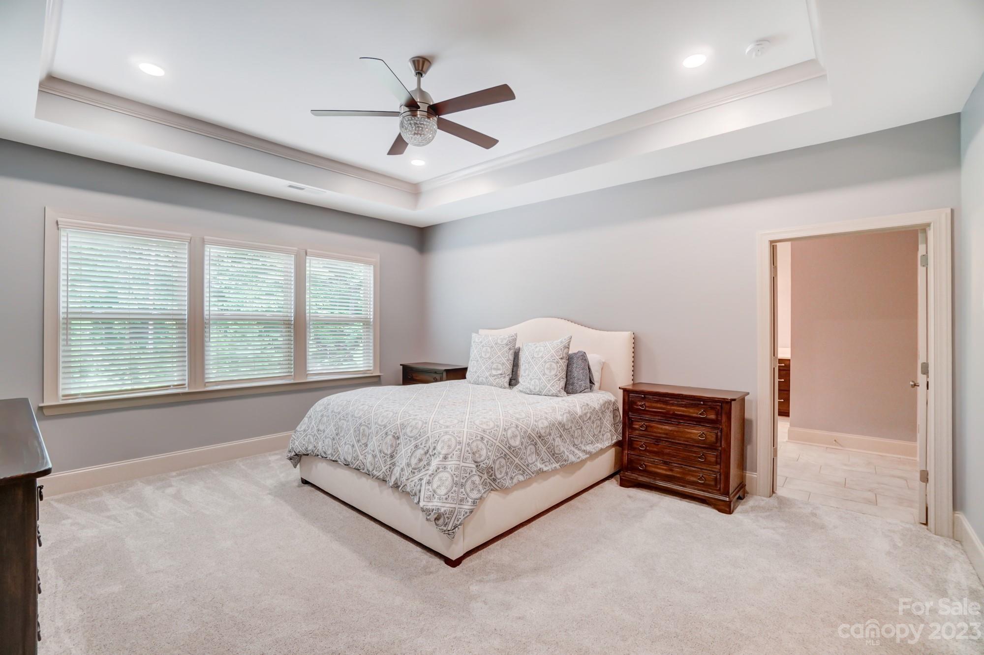 6030 Fallondale Road Waxhaw, NC 28173 - Photo 23 of 48 a spacious bedroom with a large bed and a chandelier