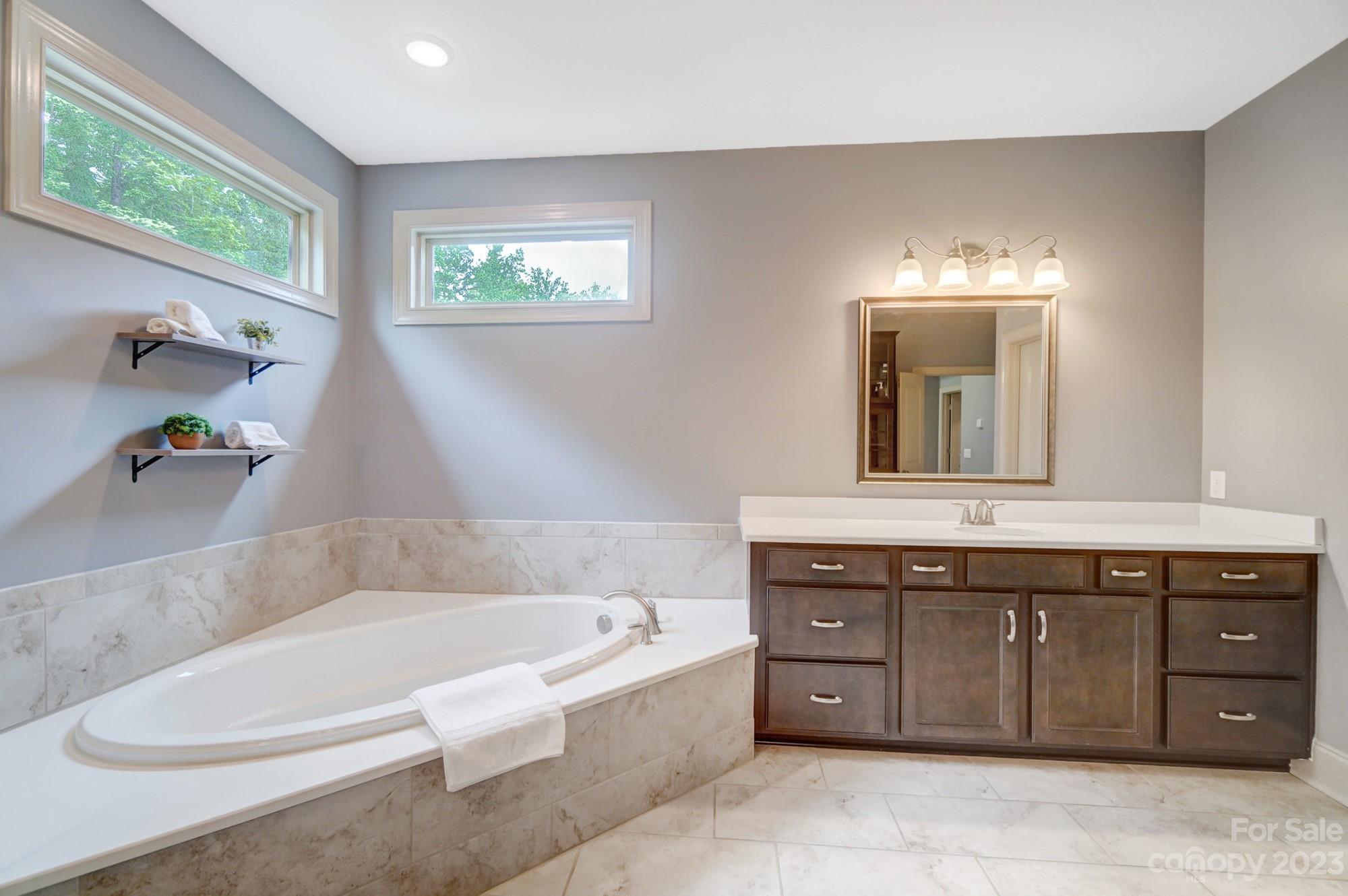 6030 Fallondale Road Waxhaw, NC 28173 - Photo 26 of 48 a bathroom with a tub a sink and a window