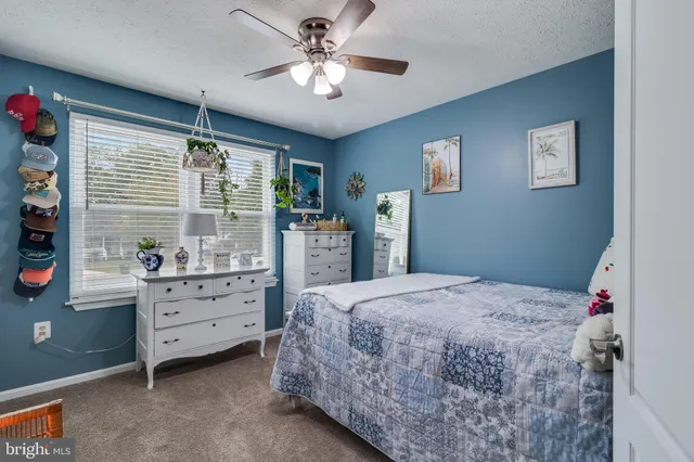 a bedroom with a bed dresser and a window