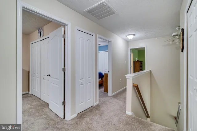 a view of a hallway and closet with mirror