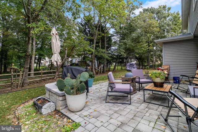 a view of a patio with couches and a table and chairs with wooden fence