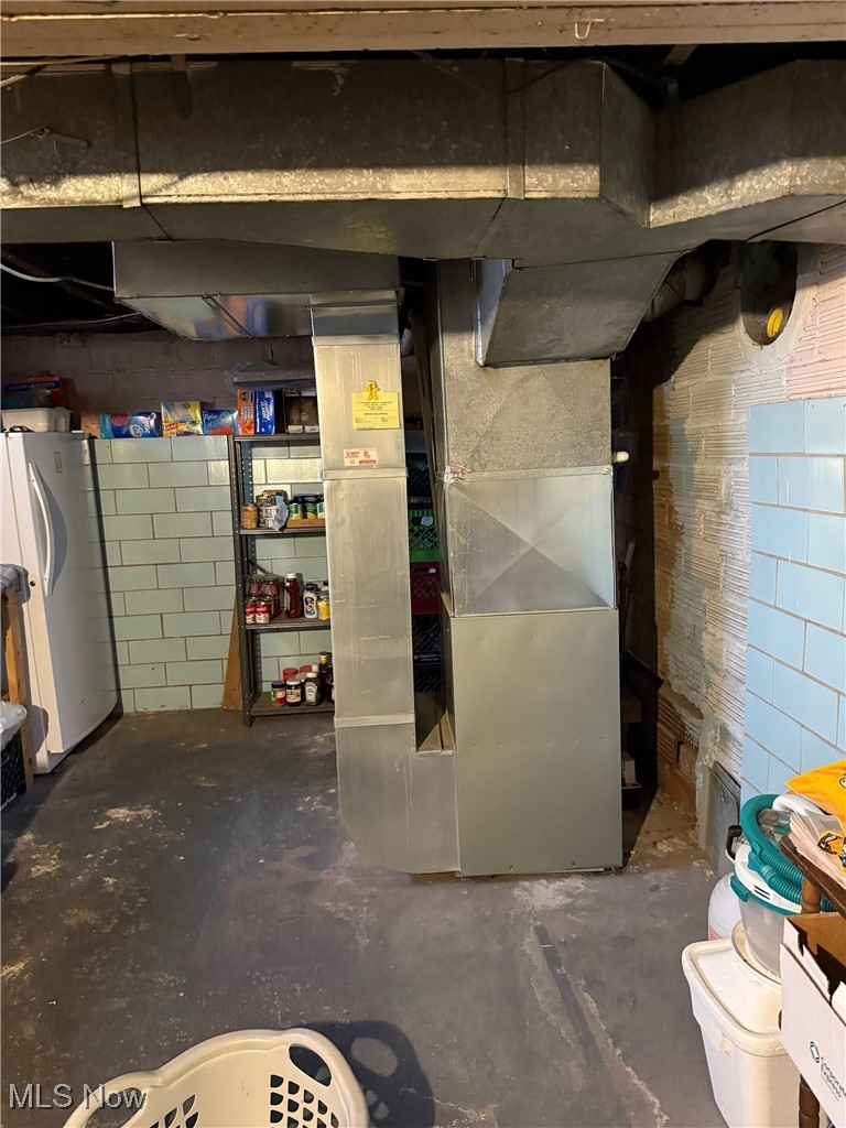1311 Warner Road Southeast Canton, OH 44707 - Photo 12 of 14 Unfinished basement with freestanding refrigerator and heating unit