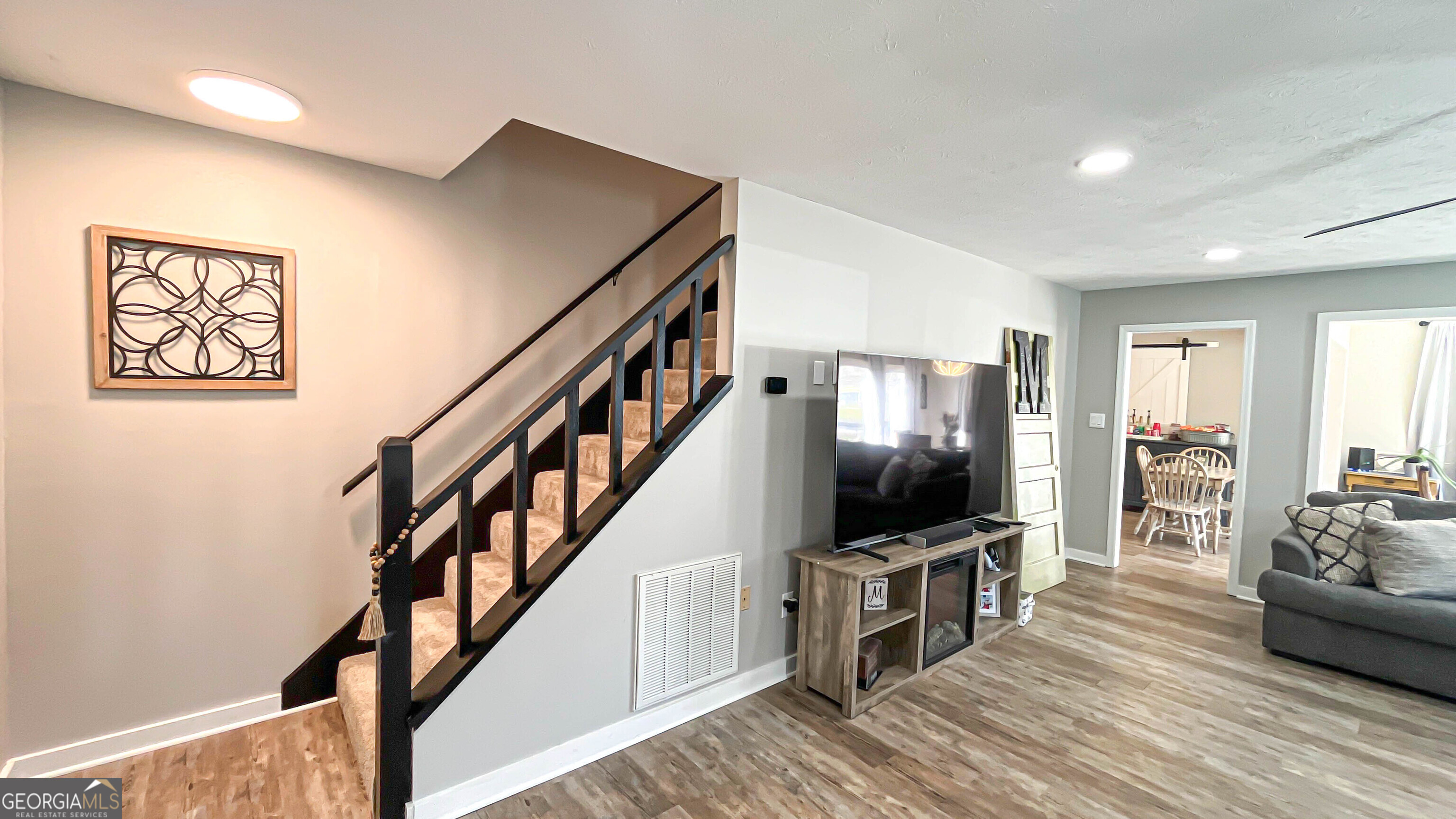 587 Highway 41 Milner, GA 30257 - Photo 22 of 172 a living room with wooden floor and a flat screen tv