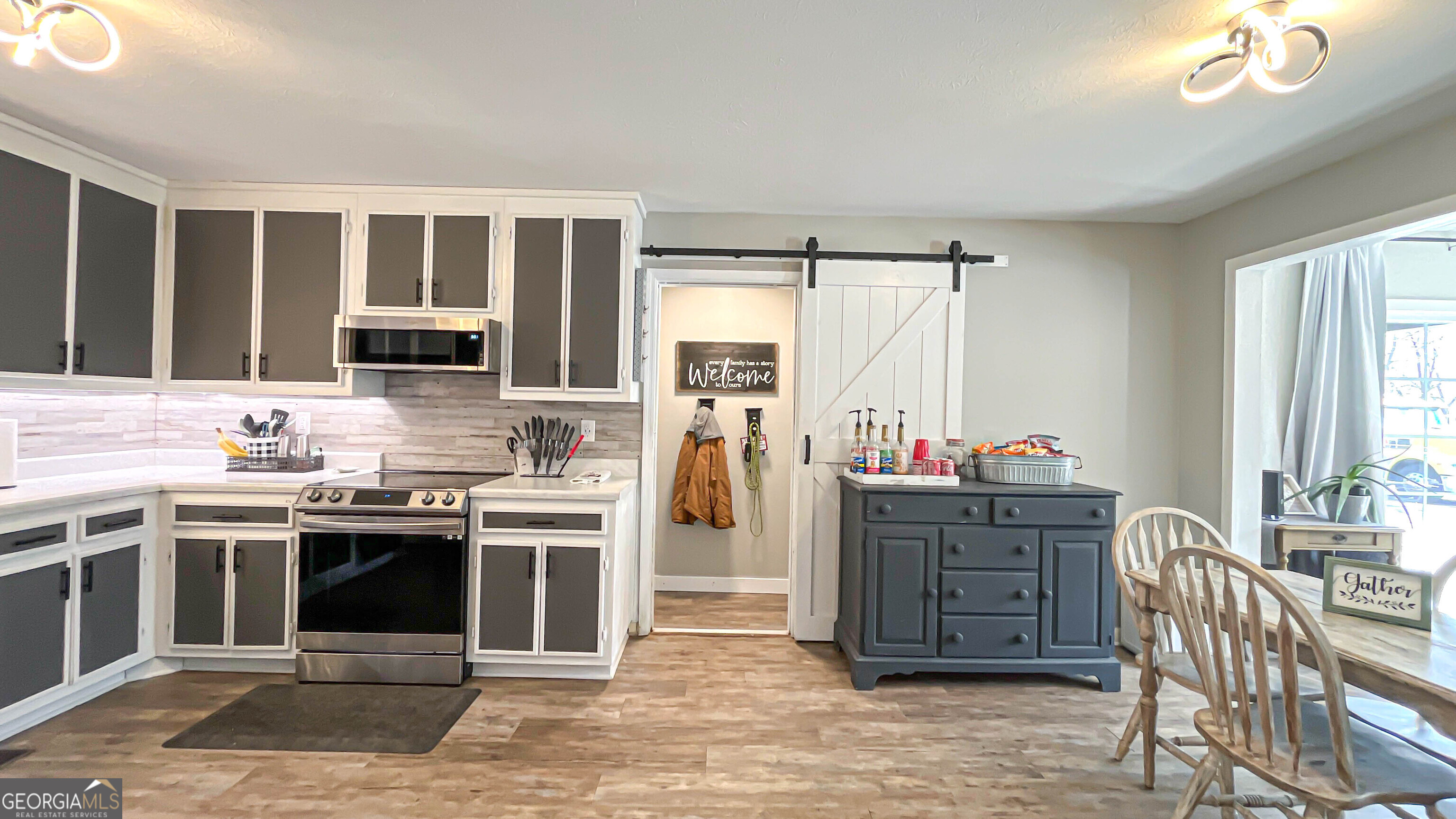 587 Highway 41 Milner, GA 30257 - Photo 24 of 172 a kitchen with stainless steel appliances kitchen island granite countertop a stove top oven a sink dishwasher a dining table and chairs with wooden floor