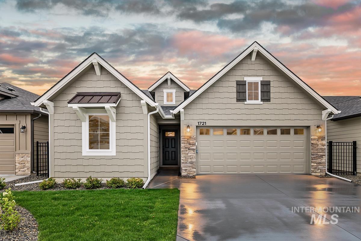 1700 East Hadler Street Meridian, ID 83642 - Photo 1 of 25 Single-story residence featuring light gray siding with shake accents, a dark gray main entry door, and a two-car garage with transom windows