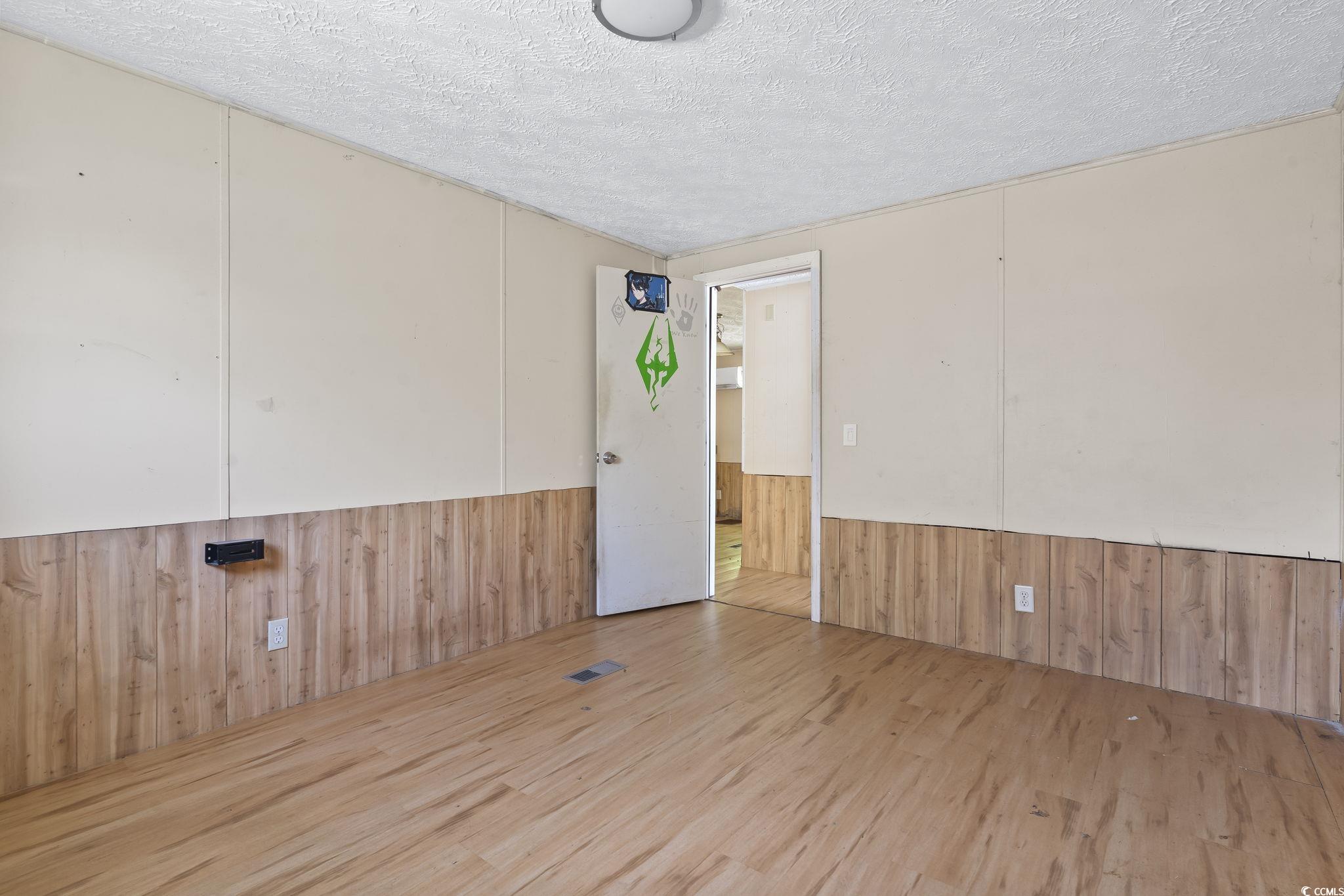 718 Reef Road Myrtle Beach, SC 29588 - Photo 15 of 20 Spare room featuring wooden walls, a textured ceil