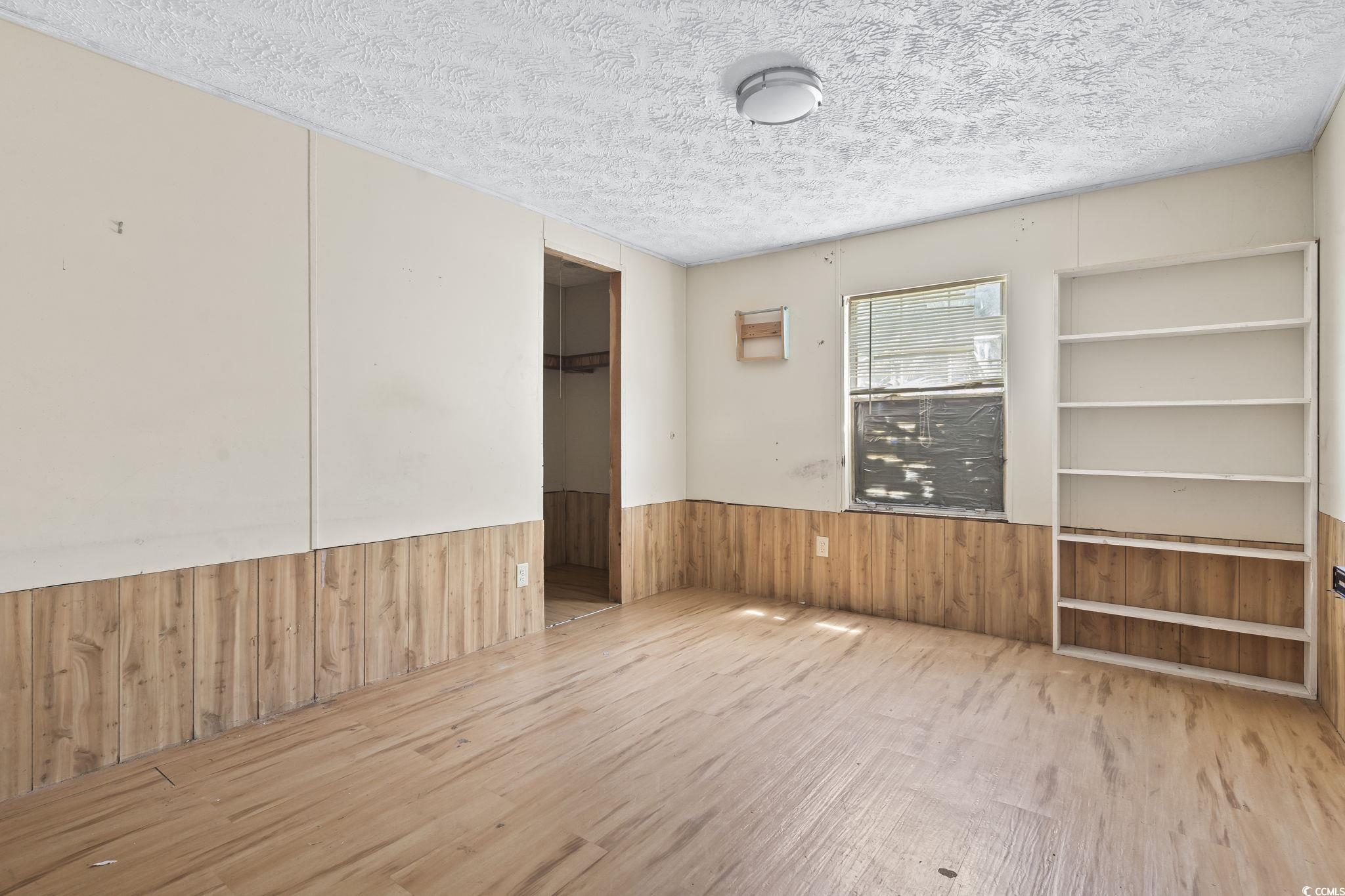 718 Reef Road Myrtle Beach, SC 29588 - Photo 16 of 20 Spare room featuring wooden walls, a wainscoted wa