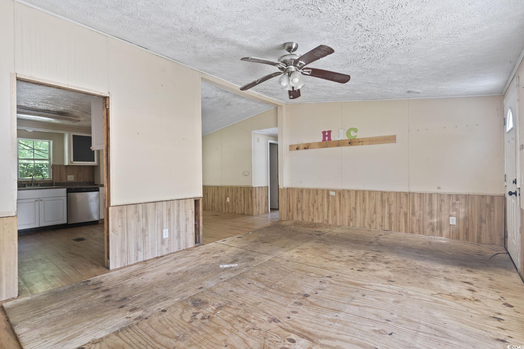 718 Reef Road Myrtle Beach, SC 29588 - Photo 6 of 20 Unfurnished room featuring ceiling fan, wainscotin