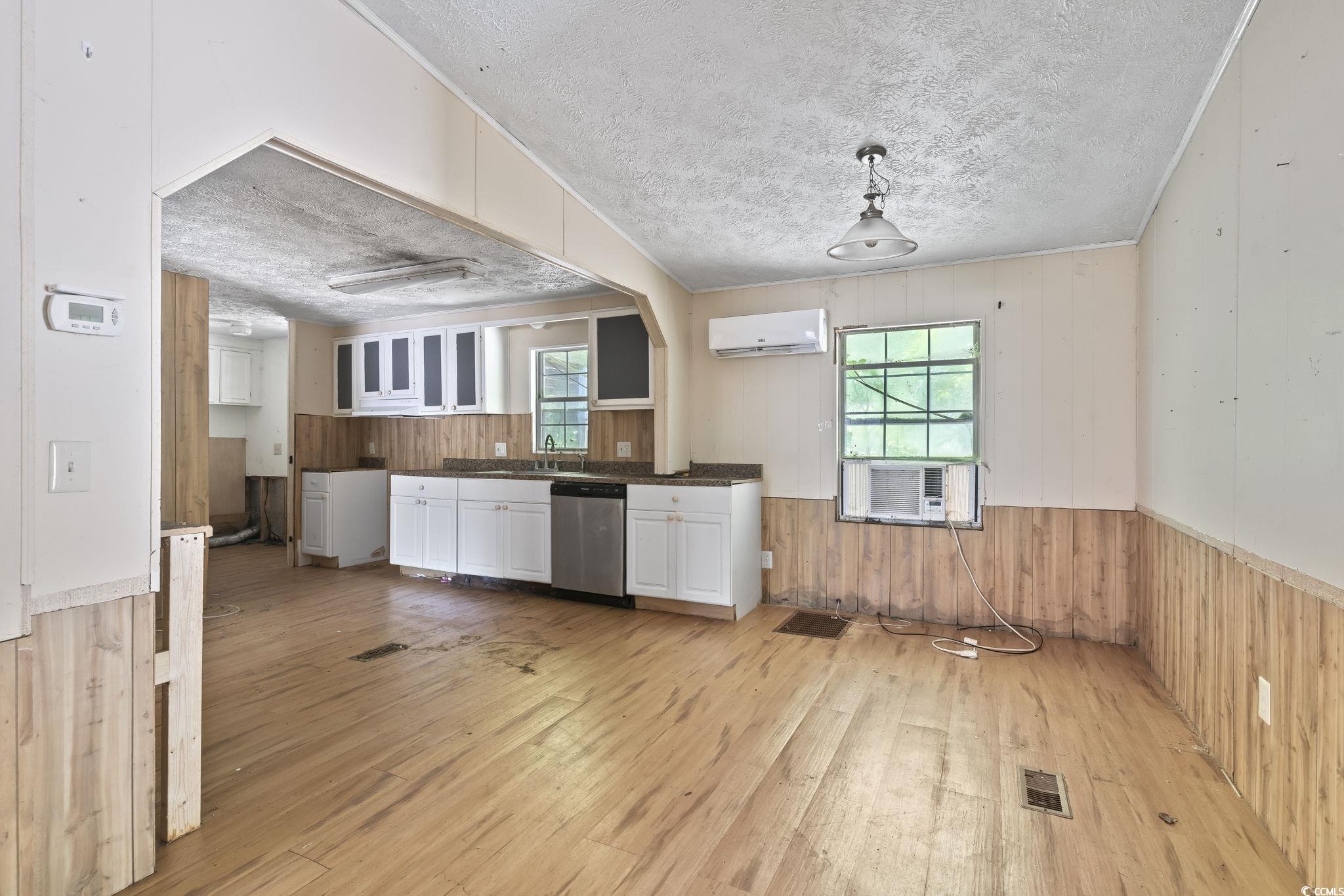 718 Reef Road Myrtle Beach, SC 29588 - Photo 7 of 20 Kitchen featuring wood walls, a wall unit AC, ligh