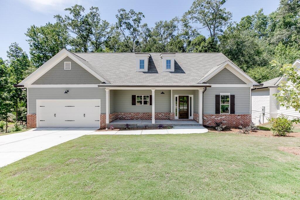 a front view of a house with a garden and trees