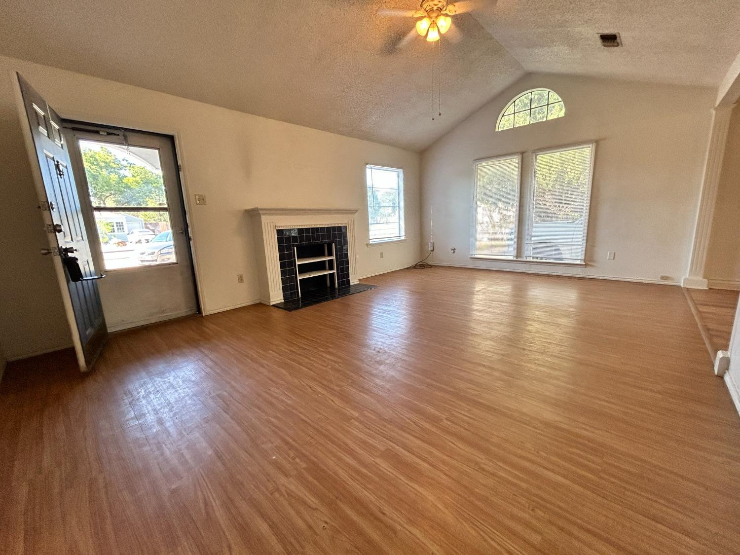 2216 30th Street, Unit FRONT Lubbock, TX 79411 - Photo 2 of 11 an empty room with windows fireplace and wooden floor