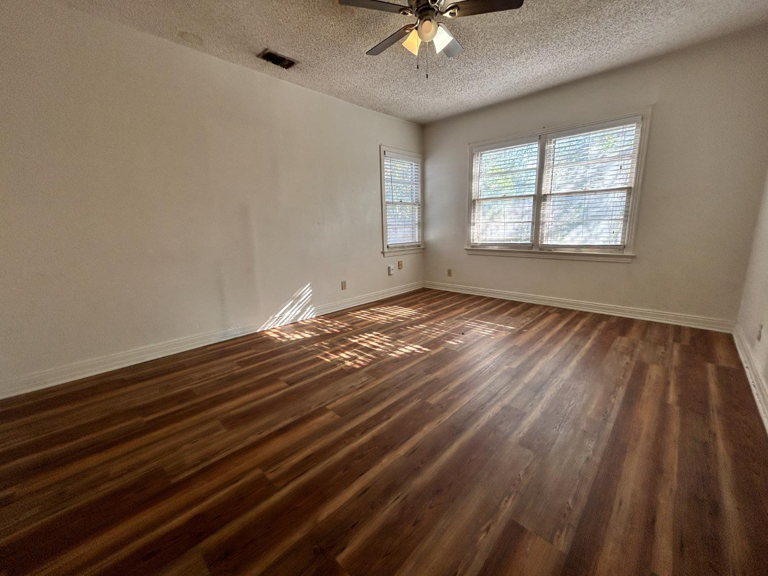 2216 30th Street, Unit FRONT Lubbock, TX 79411 - Photo 3 of 11 a view of an empty room with wooden floor and a window