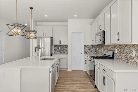 a kitchen with a sink stove and cabinets