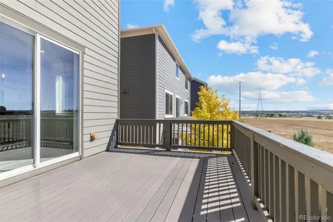 a view of a swimming pool with lawn chairs and wooden fence