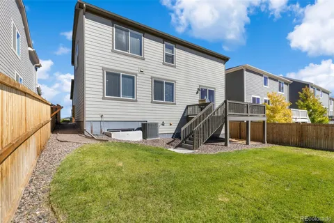a view of a house with a wooden deck and a chair