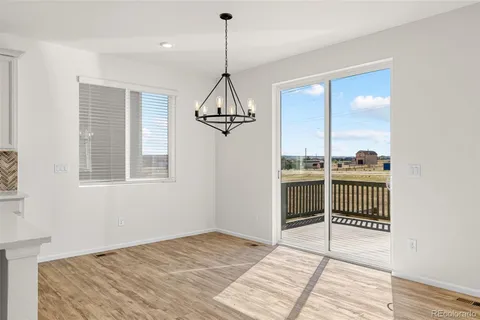 a view of a room with wooden floor and a chandelier