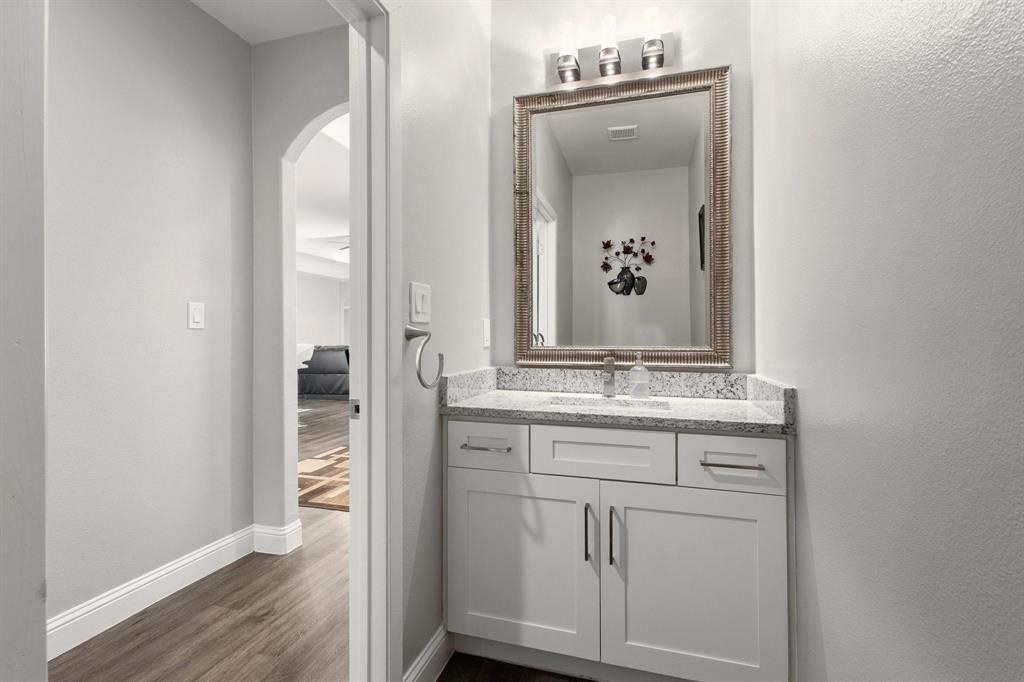 104 4th Street Trenton, TX 75490 - Photo 12 of 33 a bathroom with a granite countertop sink and a mirror
