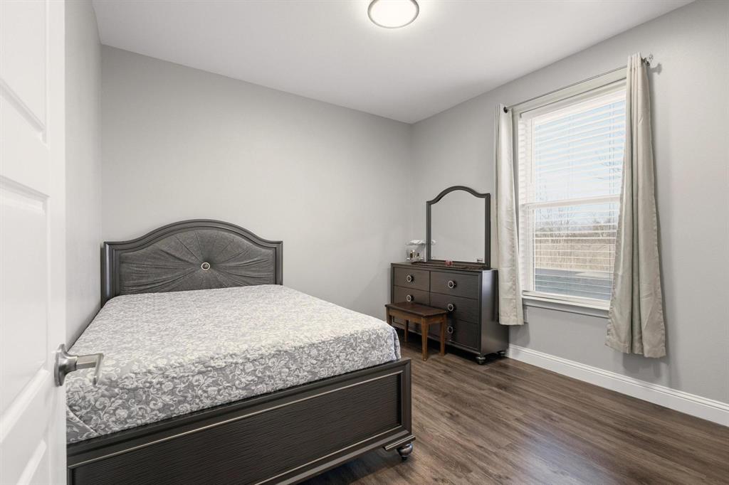 104 4th Street Trenton, TX 75490 - Photo 20 of 33 a bedroom with a bed and wooden floor