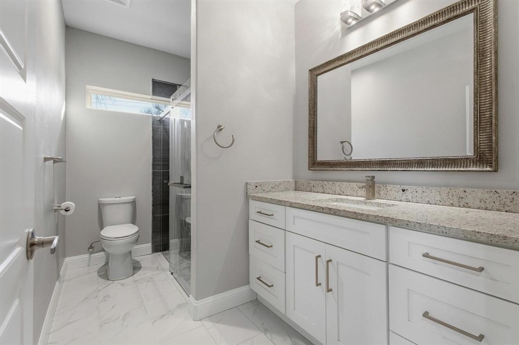 104 4th Street Trenton, TX 75490 - Photo 21 of 33 a bathroom with a toilet a sink a vanity and mirror
