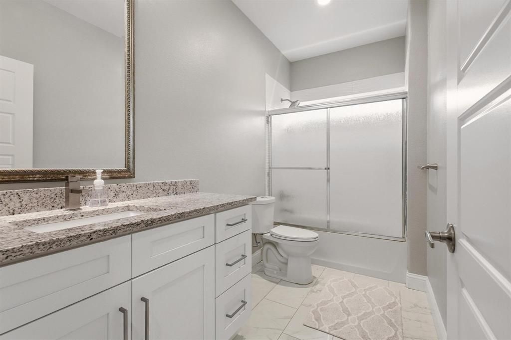 104 4th Street Trenton, TX 75490 - Photo 24 of 33 a bathroom with a granite countertop sink toilet mirror and a shower
