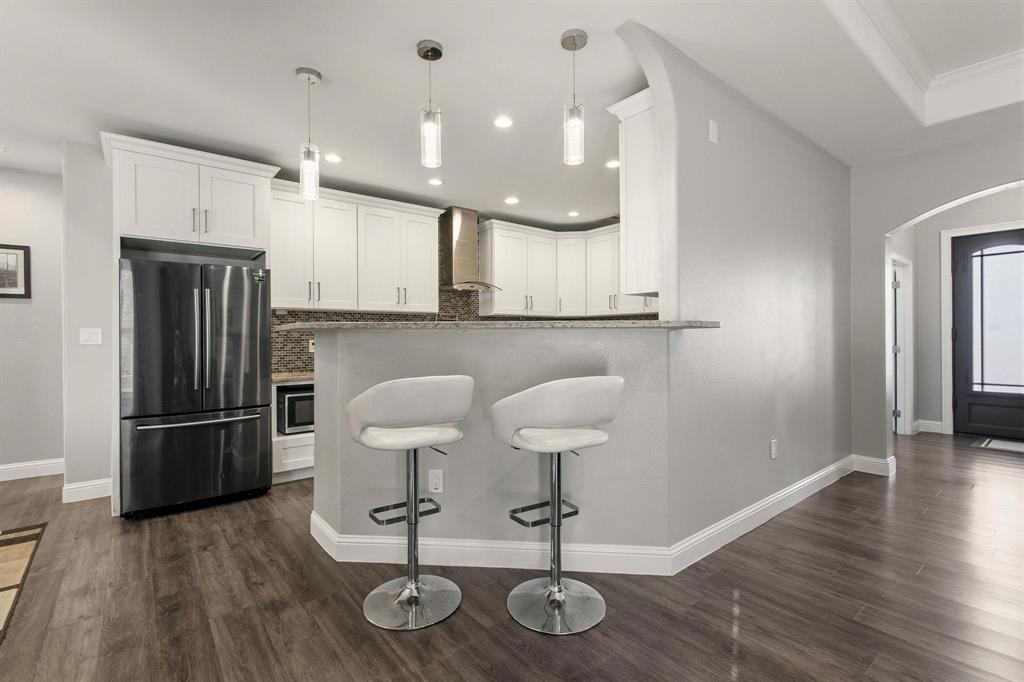 104 4th Street Trenton, TX 75490 - Photo 7 of 33 a kitchen with stainless steel appliances a refrigerator and wooden floor