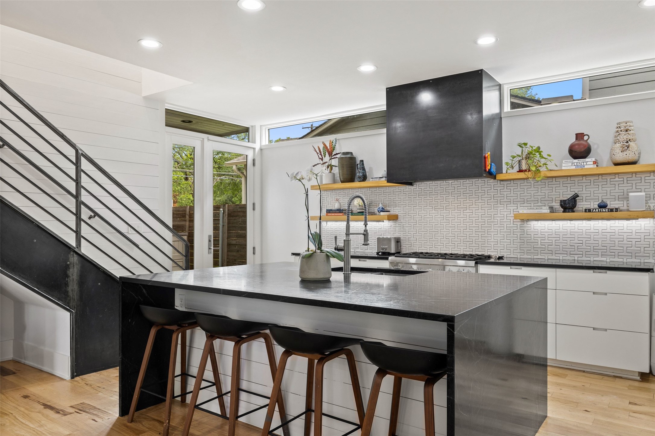 2000 Rundell Place Austin, TX 78704 - Photo 6 of 38 A striking kitchen island with ample seating complements the stylish range hood and floating shelves.