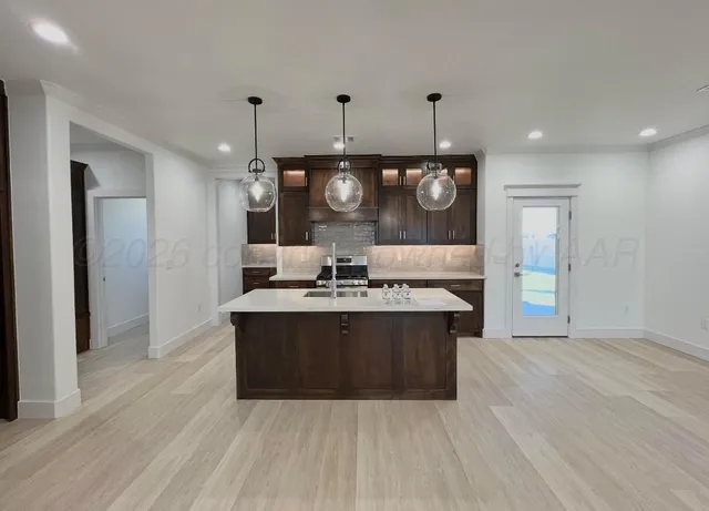 a view of a kitchen with a sink and refrigerator