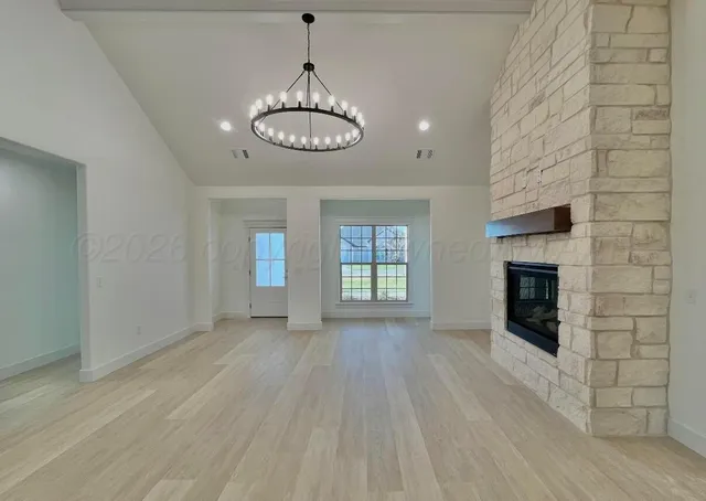a view of a room with wooden floor fireplace and window