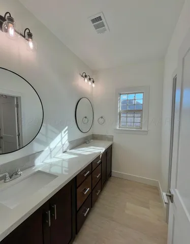a bathroom with a granite countertop sink a toilet and a mirror