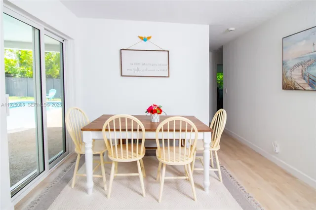 a view of a dining room with furniture a potted plant and outside view