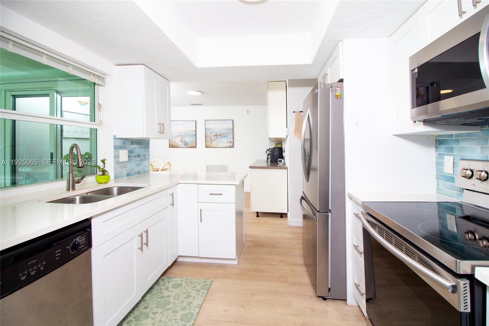 107 Winged Foot Lane Boca Raton, FL 33431 - Photo 17 of 46 a kitchen with a sink stove and refrigerator