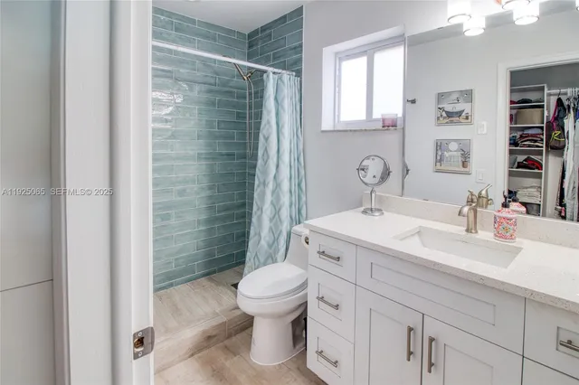 a bathroom with a sink toilet vanity and shower