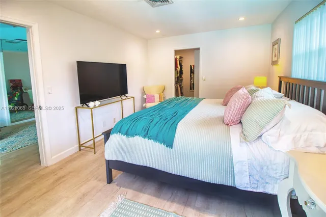 a bedroom with a bed and a flat screen tv