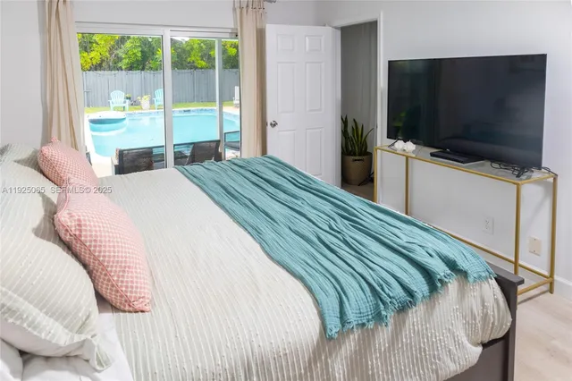 a bedroom with a bed and a flat screen tv