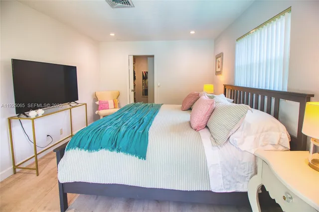 a bedroom with a bed and a flat screen tv