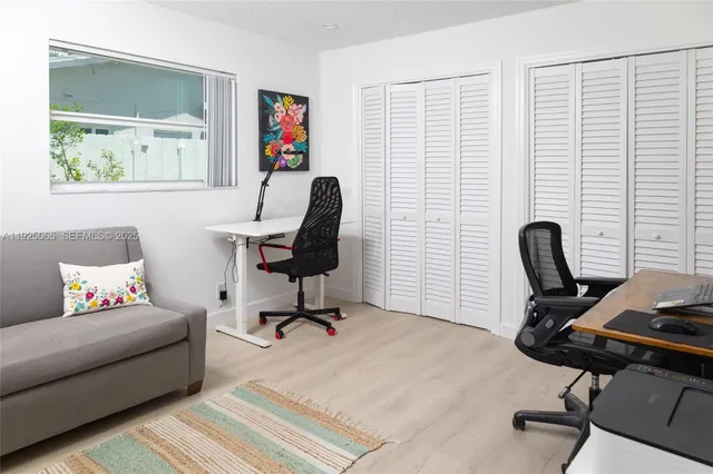 a view of a workspace with furniture and a window