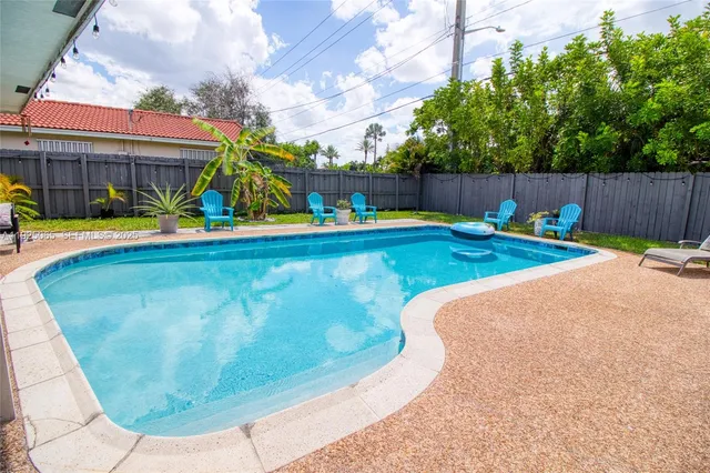 a view of a house with backyard and sitting area
