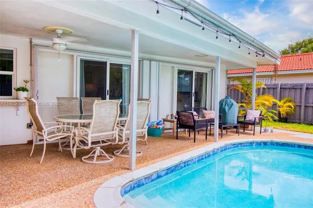 a living room with furniture a dining table and chairs with floor to ceiling window